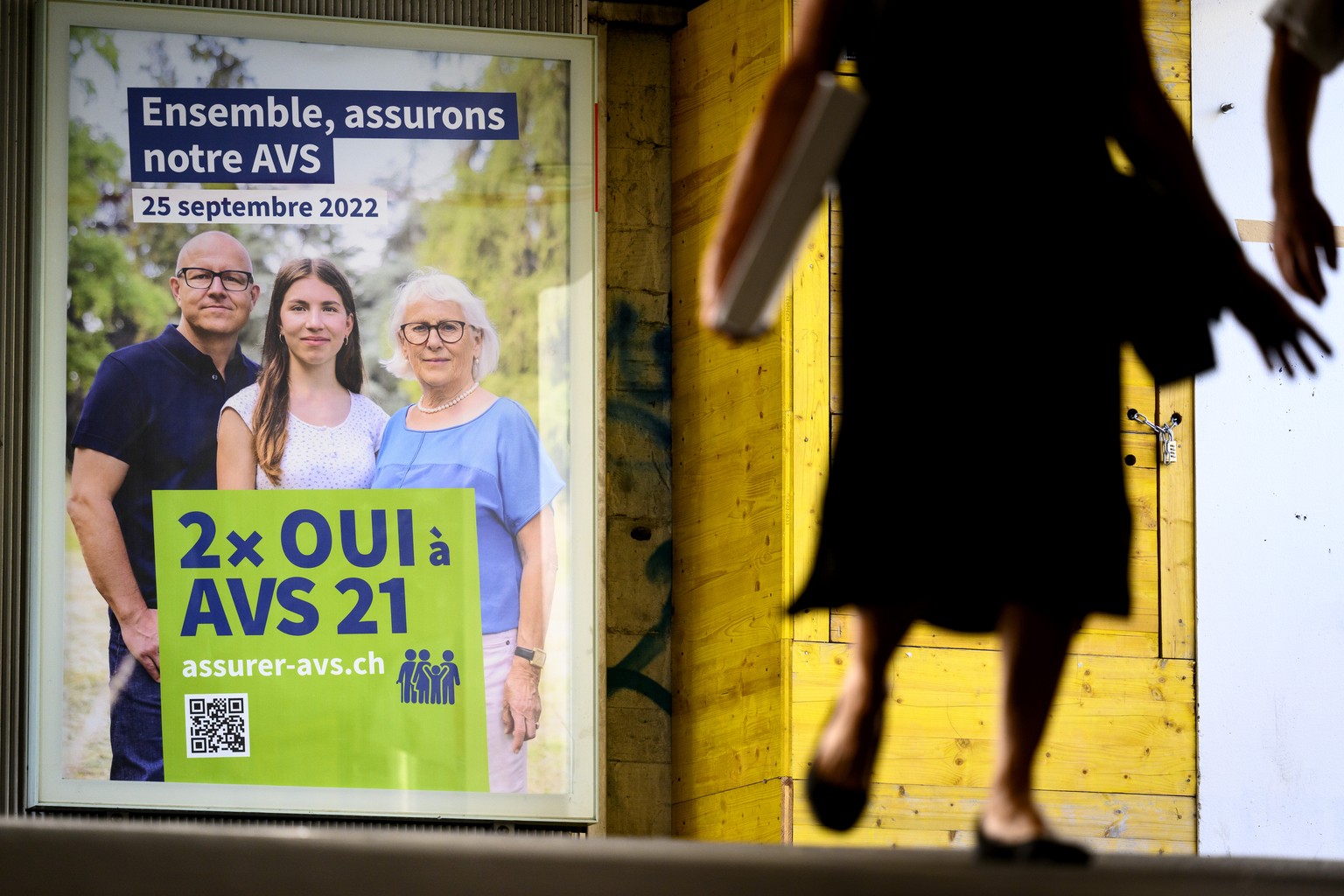 Une personne marche devant une affiche invitant a voter &quot;2x Oui a la reforme de l&#039;Assurance-vieillesse et survivants (AVS) &quot; ce lundi 5 septembre 2022 a Lausanne. Le 25 septembre procha ...