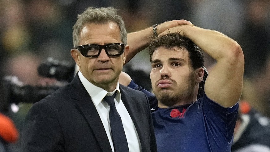 France&#039;s head coach Fabien Galthie, left, and Antoine Dupont react at the end of the Rugby World Cup quarterfinal match between France and South Africa at the Stade de France in Saint-Denis, near ...