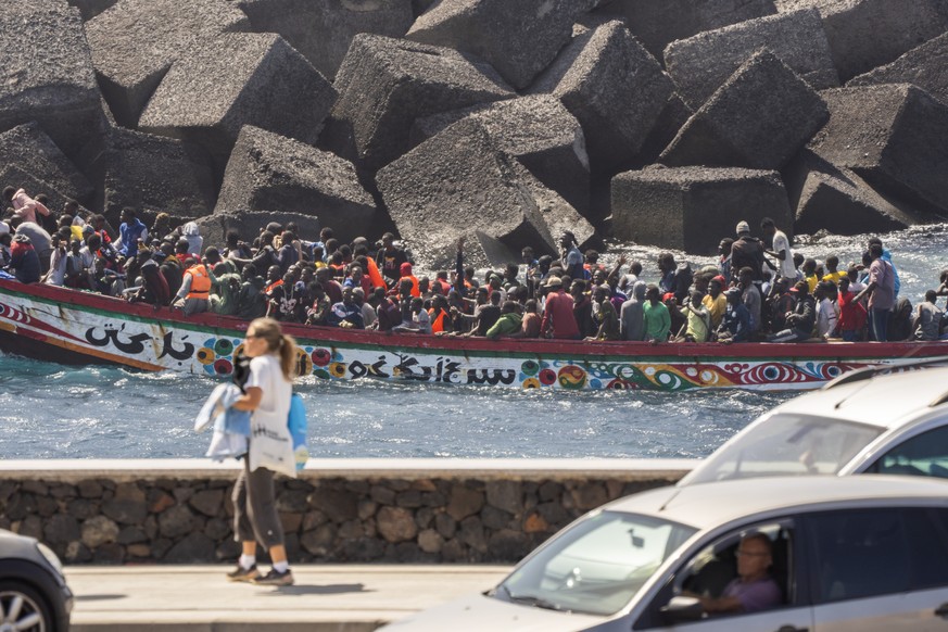 Migrants crowd a wooden boat as they arrive at the port in La Restinga on the Canary island of El Hierro, Spain, Sunday, Aug. 18, 2024. Emergency services on Spain&#039;s Canary Islands say 175 migran ...