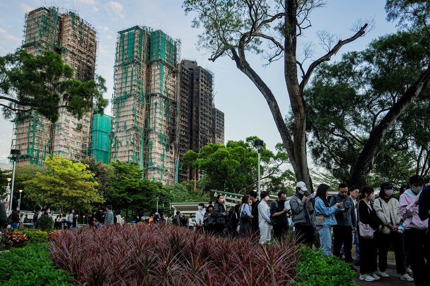 epa12556625 People lay floral tributes for the victims of the fire at the Wang Fuk Court residential estate in the Tai Po district of Hong Kong, China, 29 November 2025. The city is mourning 128 peopl ...