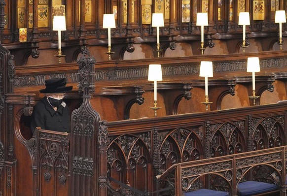 Britain&#039;s Queen Elizabeth II looks on as she sits alone in St. George��&amp;#x2122;s Chapel during the funeral of Prince Philip, the man who had been by her side for 73 years, at Windsor Castle,  ...