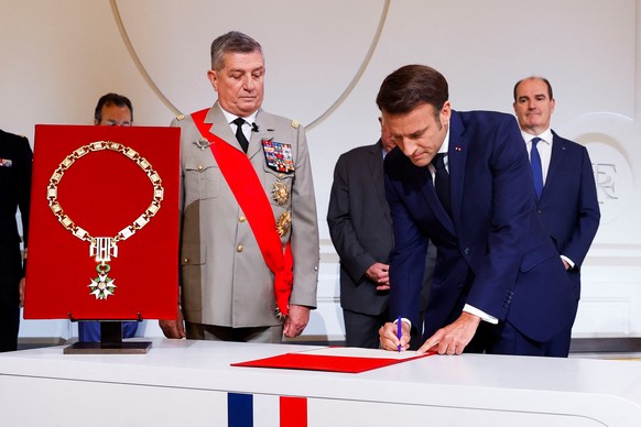 Le président sortant, Emmanuel Macron, signe le document qui le déclare officiellement de nouveau président de la République Française le 7 mai 2022. 