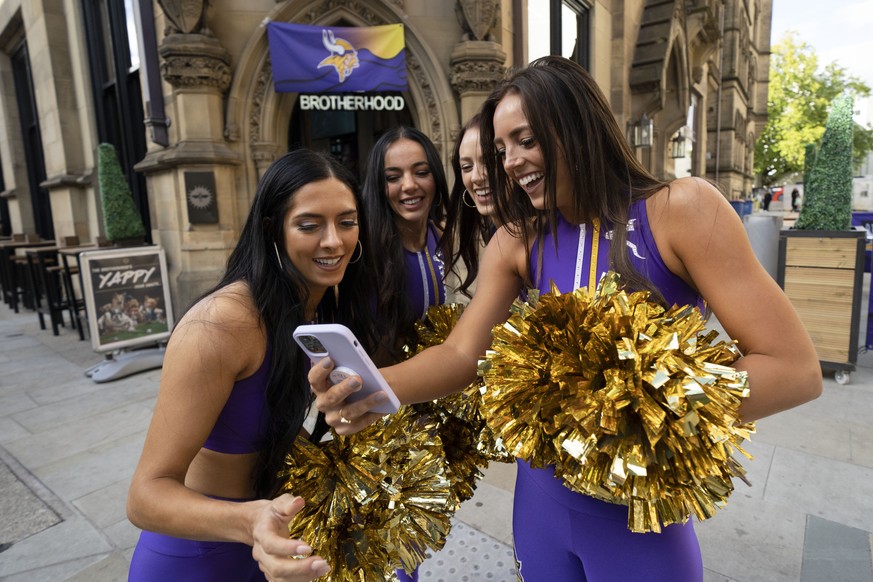 Cheerleaders for the The Minnesota Vikings check the footage after recording a TikTok video at a fan interaction event at The Brotherhood Of Pursuits And Pastimes sports bar in Manchester, England, We ...