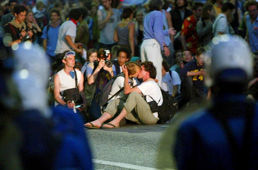 Two protesters kiss in front of Geneva riot police in Geneva, Switzerland, Monday night, June 2, 2003. After heavy riots on Saturday and Sunday, demonstrators continued to show their displeasures with ...