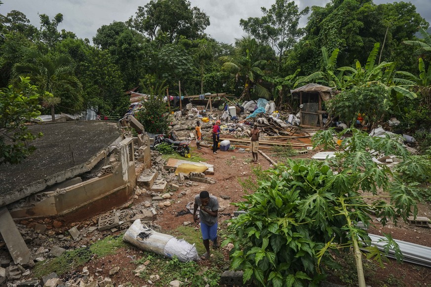 People recover belongings from the rubble of their home destroyed by the earthquake in Fleurant, Haiti, Tuesday, Aug. 17, 2021, three days after the 7.2 -magnitude quake hit the Caribbean nation. (AP  ...