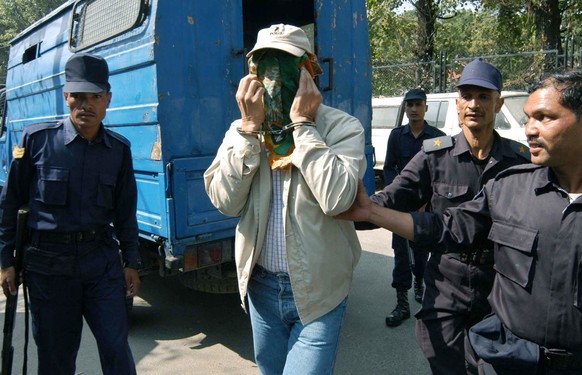 Confessed international serial killer Charles Sobhraj, 59, is escorted by armed policemen to a court in Katmandu, Nepal, Thursday, Oct. 16, 2003. The second day of preliminary hearing began Thursday a ...