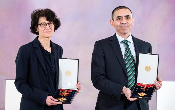 epa09083589 Ugur Sahin (R) and his wife Oezlem Tuereci (L), founders of the vaccine developer BioNTech, present their Grand Cross of Merit with Star of the Order of Merit of the Federal Republic of Ge ...