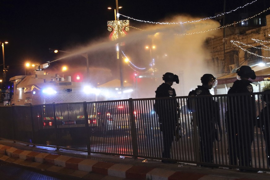 Israeli police use a water cannon to disperse Palestinian protesters from the area near the Damascus Gate to the Old City of Jerusalem after clashes at the Al-Aqsa Mosque compound, Friday, May 7, 2021 ...