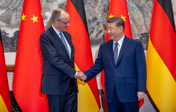 epa12775950 Chinese President Xi Jinping (R) welcomes German Chancellor Friedrich Merz (L) at the state guesthouse for bilateral talks in Beijing, China, 25 February 2026. Merz is visiting China for t ...