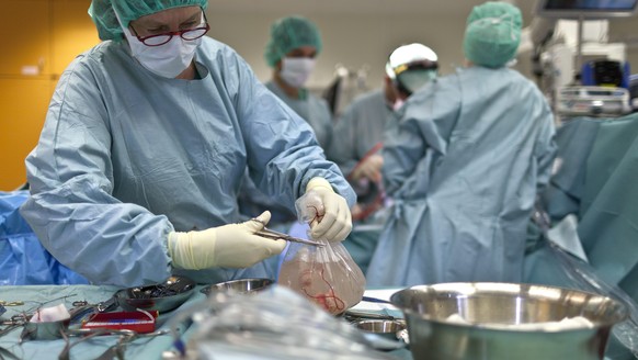 ZUR ORGANSPENDEN-DEBATTE IM STAENDERAT STELLEN WIR IHNEN FOLGENDES THEMENBILD ZUR VERFUEGUNG - Ein Arzt oeffnet im Kinderspital Zuerich einen Sack, in dem sich ein gesundes Herz befindet. Das Herz sol ...