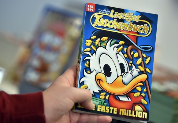 Der 12-j‰hrige Jakob h‰lt am 30.11.2017 in Berlin im LTB Popup-Shop ein Buch Lustiges Taschenbuch mit einer Geschichte um Dagobert Duck in der Hand. (zu dpa "Ente mit 70 - Onkel Dagobert hat Gebu ...