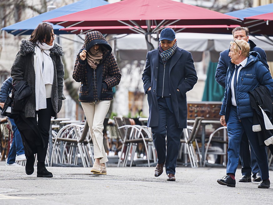 Deux membres de la famille Hinduja, soit la belle-fille et le fils de Prakash Hinduja (au centre avec la capuche et avec la casquette), arrivent au Palais de justice à Genève.