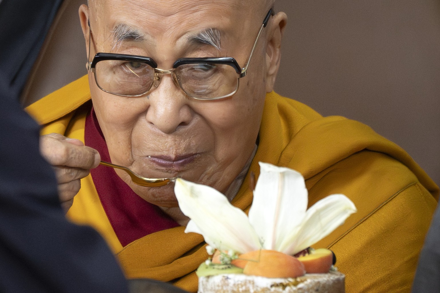 Tibetan spiritual leader the Dalai Lama eats a cake during his 90th birthday celebrations at the Tsuglakhang temple in Dharamshala, India, Sunday, July 6, 2025.(AP Photo/Ashwini Bhatia)