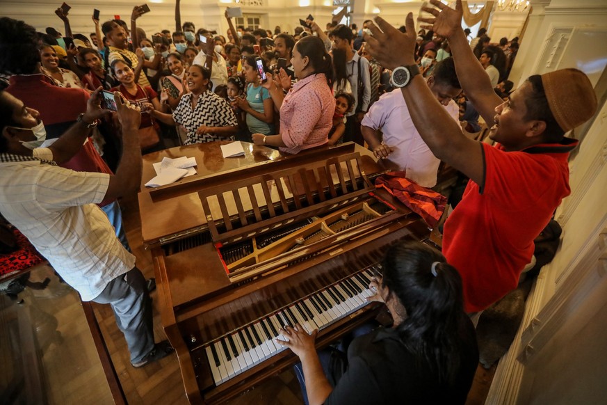 epa10065275 People sing songs inside the prime minister&#039;s official residence in Colombo, Sri Lanka, 11 July 2022, two days after official residences were stormed. Sri Lankan president and prime m ...