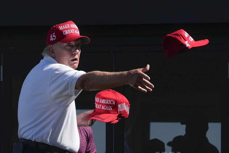 Former President Donald Trump throws autographed red hats to the crowd during the final round of the Bedminster Invitational LIV Golf tournament in Bedminster, N.J., Sunday, Aug. 13, 2023. (AP Photo/S ...