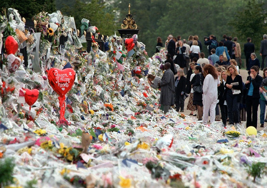 FILE - Mourners file past the tributes left in memory of Diana Princess of Wales at Kensington Palace in London, Friday, Sept. 5, 1997. It was a warm Saturday evening and journalists had gathered at a ...