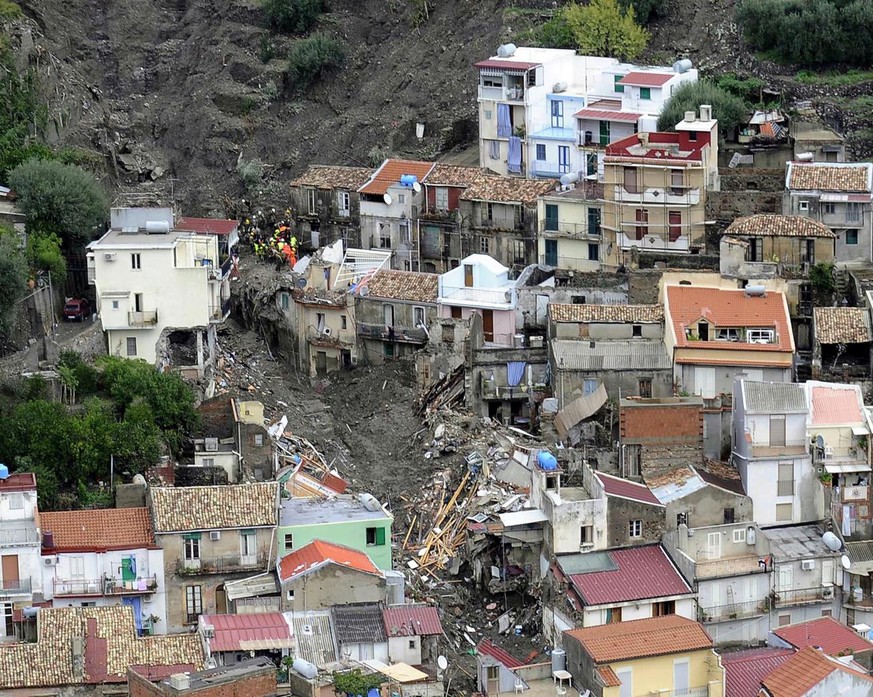 epa01885163 Rescue workers search for victims following the landslide in Giampilieri, near Messina, Sicily island, on 03 October 2009. At least 19 people were killed and at least 80 more injured as vi ...