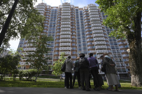 People look at a the apartment building in Moscow, Russia, damaged by a drone in an attack that authorities blamed on Ukraine, Tuesday, May 30, 2023. In Moscow, residents reported hearing explosions a ...