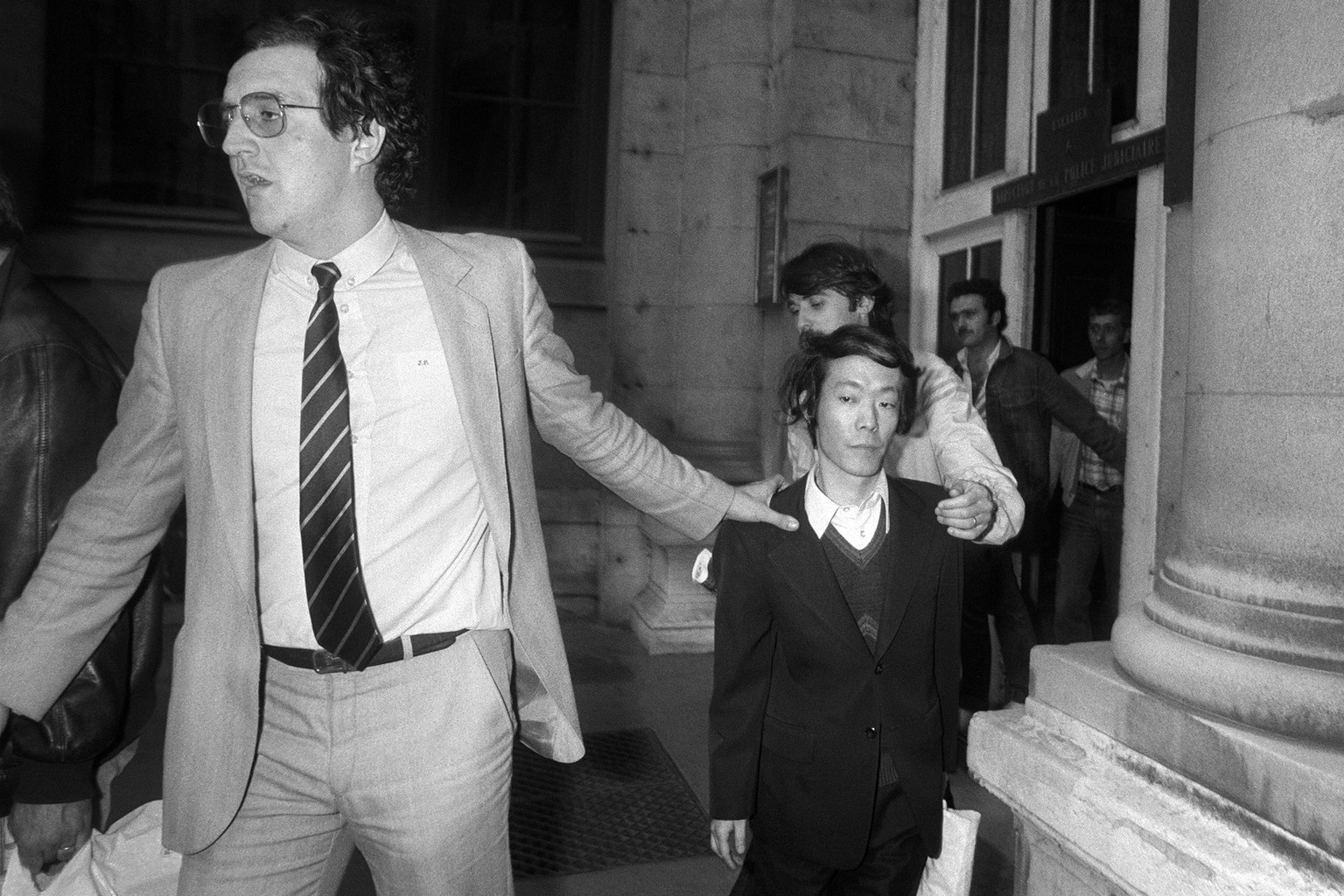 Issei Sagawa escorté par un policier en civil, à l'issue de son interrogatoire, le 17 juin 1981.