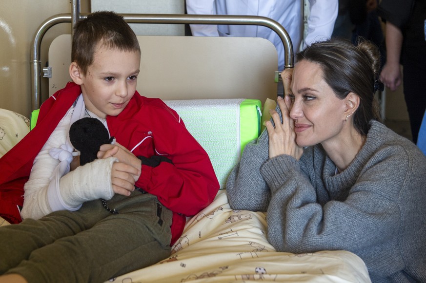 epa09921479 US Actress and UN Goodwill Ambassador Angelina Jolie comforts a young victim of the Kramatorsk railway station missile strike in Lviv children&#039;s hospital, in Western Ukraine, 30 April ...