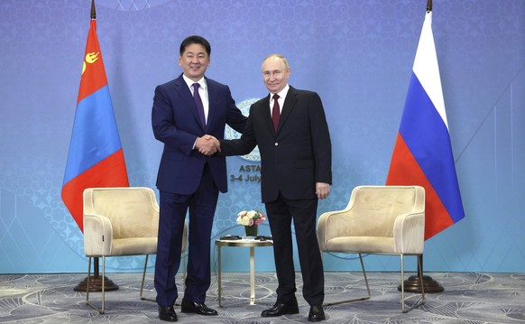 July 3, 2024, Astana, Kazakhstan: Mongolian President Ukhnaagiin Khurelsukh, left, shakes hands with Russian President Vladimir Putin, right, before the start of a bilateral meeting on the sidelines o ...