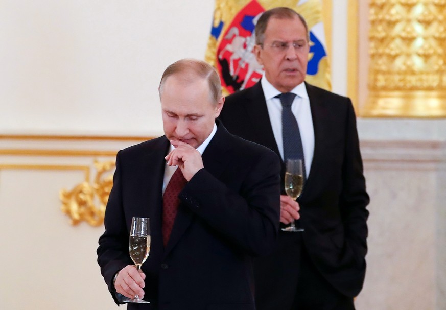 FILE - Russian President Vladimir Putin, left, and Russian Foreign Minister Sergey Lavrov prepare to toast at a ceremony of receiving credentials from foreign ambassadors in the Kremlin in Moscow, Rus ...