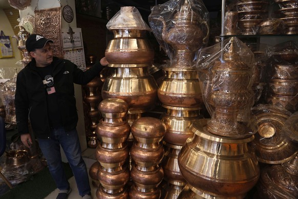 epa12723044 A shop keeper displays copper a utensil at a workshop in Srinagar, the summer capital of Indian Kashmir, 10 February 2026. The silvery layer applied to copper to prevent corrosion and make ...