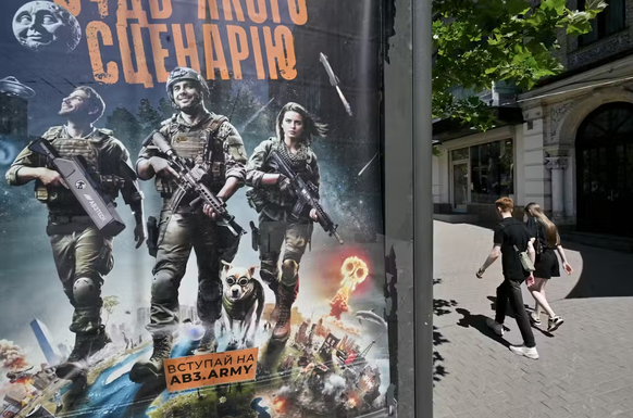 Affiche de recrutement sur laquelle on peut lire «Etre prêt à tous les scénarios», à Kiev, le 6 juillet 2025. L’esthétique emprunte aux films d’action d’Hollywood
