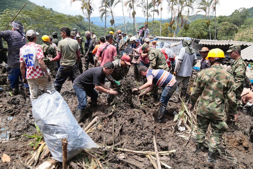 epa10071685 A handout photo made available by the Government of Antioquia shows members of the Army and relief groups while they work to rescue victims of a landslide that buried a school in Taparto,  ...