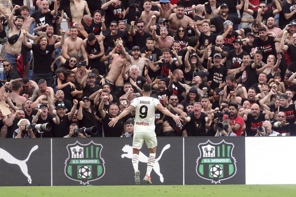 AC Milan's Olivier Giroud celebrates beneath fans after scoring his side's second goal during a Serie A soccer match between AC Milan and Sassuolo, in Reggio Emilia's Mapei Stadium, Ita ...