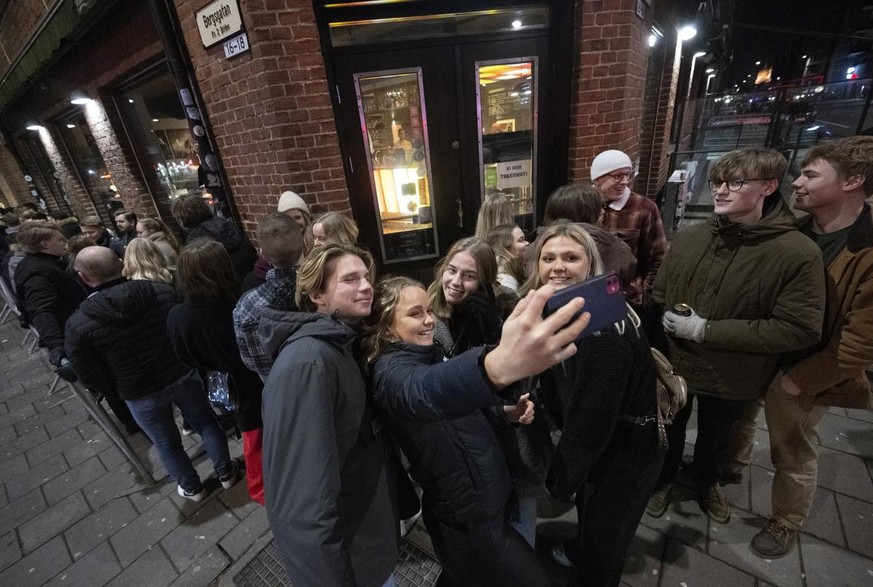 Des jeunes se prennent en photo devant une discothèque à Malmö, en Suède.