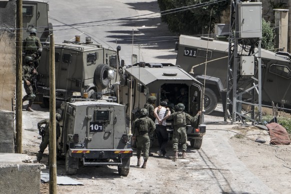 Israeli soldiers arrest a Palestinian man during a military operation in the Palestinians town of Deir al-Ghusun, near the West Bank town of Tulkarem, Saturday, May 4, 2024. (AP Photo/Majdi Mohammed)