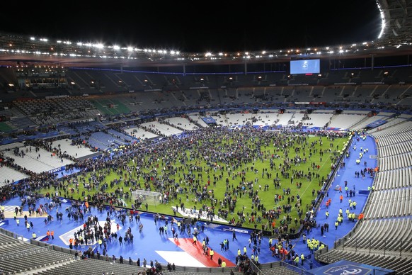 Spectators invade the pitch of the Stade de France stadium after the international friendly soccer France against Germany, Friday, Nov. 13, 2015 in Saint Denis, outside Paris. At least 35 people were  ...