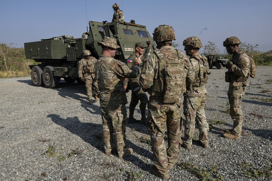 epa12893140 US Army officers talk to a Philippine Army officer beside an M142 High Mobility Artillery Rocket System (HIMARS) launcher during joint military exercises between the Philippines and the US ...