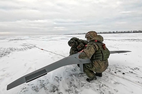 In this photo taken from video distributed by Russian Defense Ministry Press Service on Tuesday, Feb. 3, 2026, Russian soldiers prepare to launch a drone for an action in an undisclosed location in Uk ...