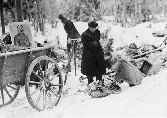 Finnische Soldaten sortieren das erbeutete Kriegsmaterial, darunter ein Bild von Josef Stalin, welches die vernichtend geschlagenen russischen Divisionen nach dem verlustreichen Winterkrieg im Norden  ...