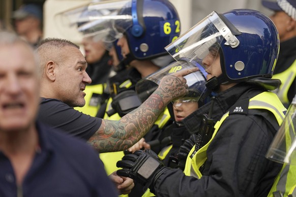 A protester points his finger towards a police officer during the &#039;Enough is Enough&#039; protest in Whitehall, London, Wednesday July 31, 2024, following the fatal stabbing of three children at  ...
