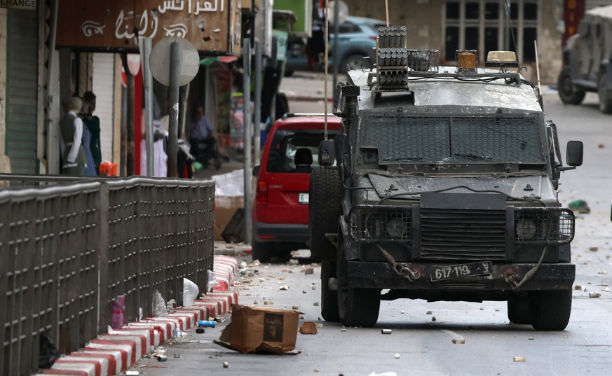epa12073220 An Israeli military vehicle at a street during clashes after an Israeli army raid in the West Bank city of Nablus, 04 May 2025. At least 40 Palestinians were wounded, including three journ ...
