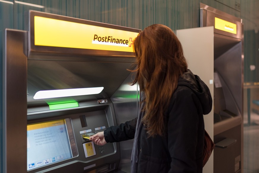 ARCHIVBILD --- Cash withdawal by a customer at a cash dispenser of PostFinance at Rennweg in Zurich, Switzerland, on October 30, 2018. (KEYSTONE/Christian Beutler)..Bargeldbezug einer Kundin an einem  ...
