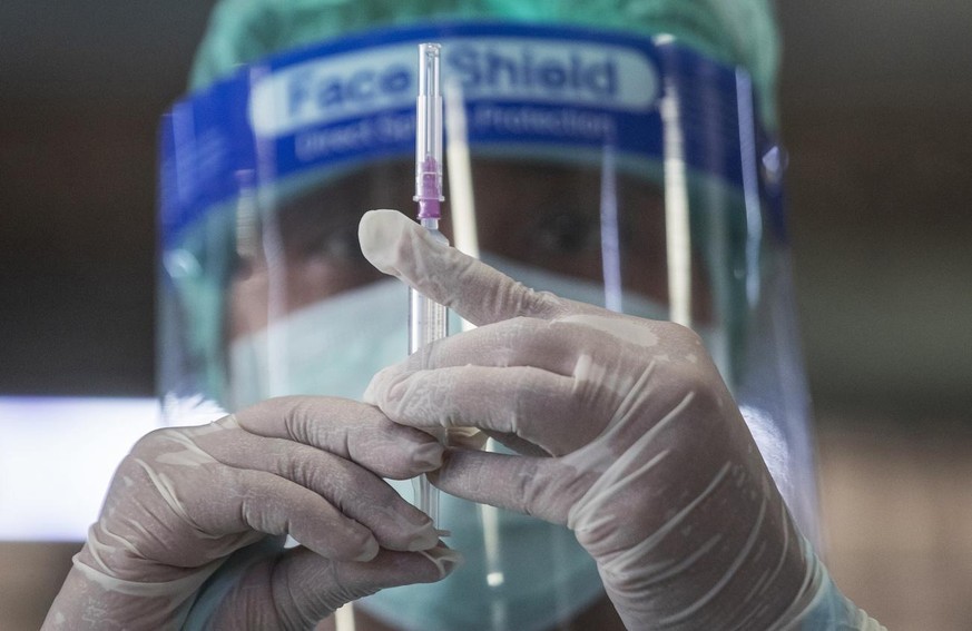 A health worker prepares a dose of the Sinovac COVID-19 vaccine for people who live in a popular market area where a new cluster of Covid 19 infections was found in Bangkok, Thailand, Wednesday, March ...