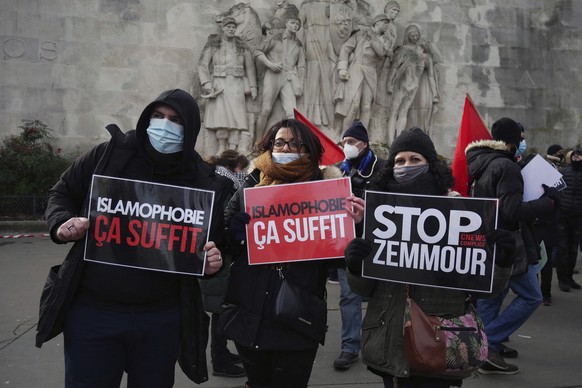 FILE - In this Feb. 14, 2021 file photo, activists hold placards reading &#039;Islamophobia is enough&#039; and &#039;Stop Zemmour&#039; during a gathering in Paris. Eric Zemmour is a rabble-rousing t ...