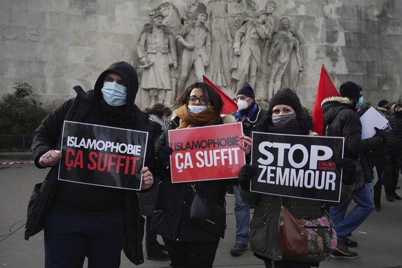 FILE - In this Feb. 14, 2021 file photo, activists hold placards reading 'Islamophobia is enough' and 'Stop Zemmour' during a gathering in Paris. Eric Zemmour is a rabble-rousing t ...