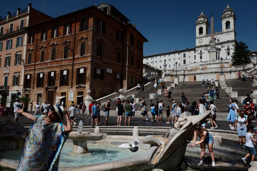 People cool off during an ongoing heat wave with temperatures reaching 40 degrees, at Piazza di Spagna, on July 16, 2023 in Rome, Italy. (Photo by Massimo Valicchia/NurPhoto via Getty Images)
