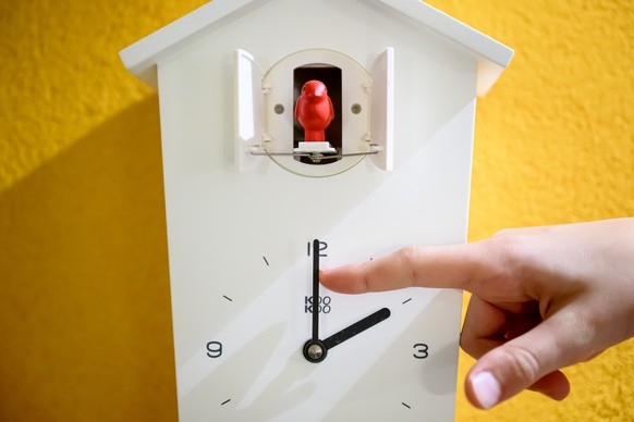 Une main regle les aiguilles de 3h a 2h du matin sur une pendule coucou lors du changement d&#039;horaire ce mercredi 23 octobre 2024 a Daillens. Tous les ans, le passage a l&#039;heure d&#039;ete, es ...