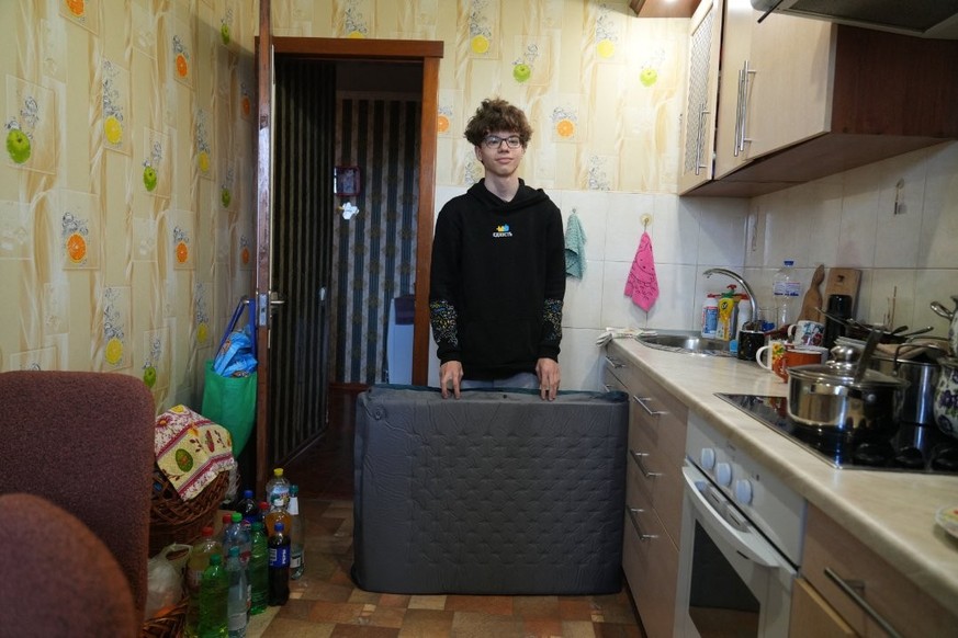 Bogdan Levchikov, avec le matelas que lui et sa mère utilisent pour dormir à l'abris des frappes russes.