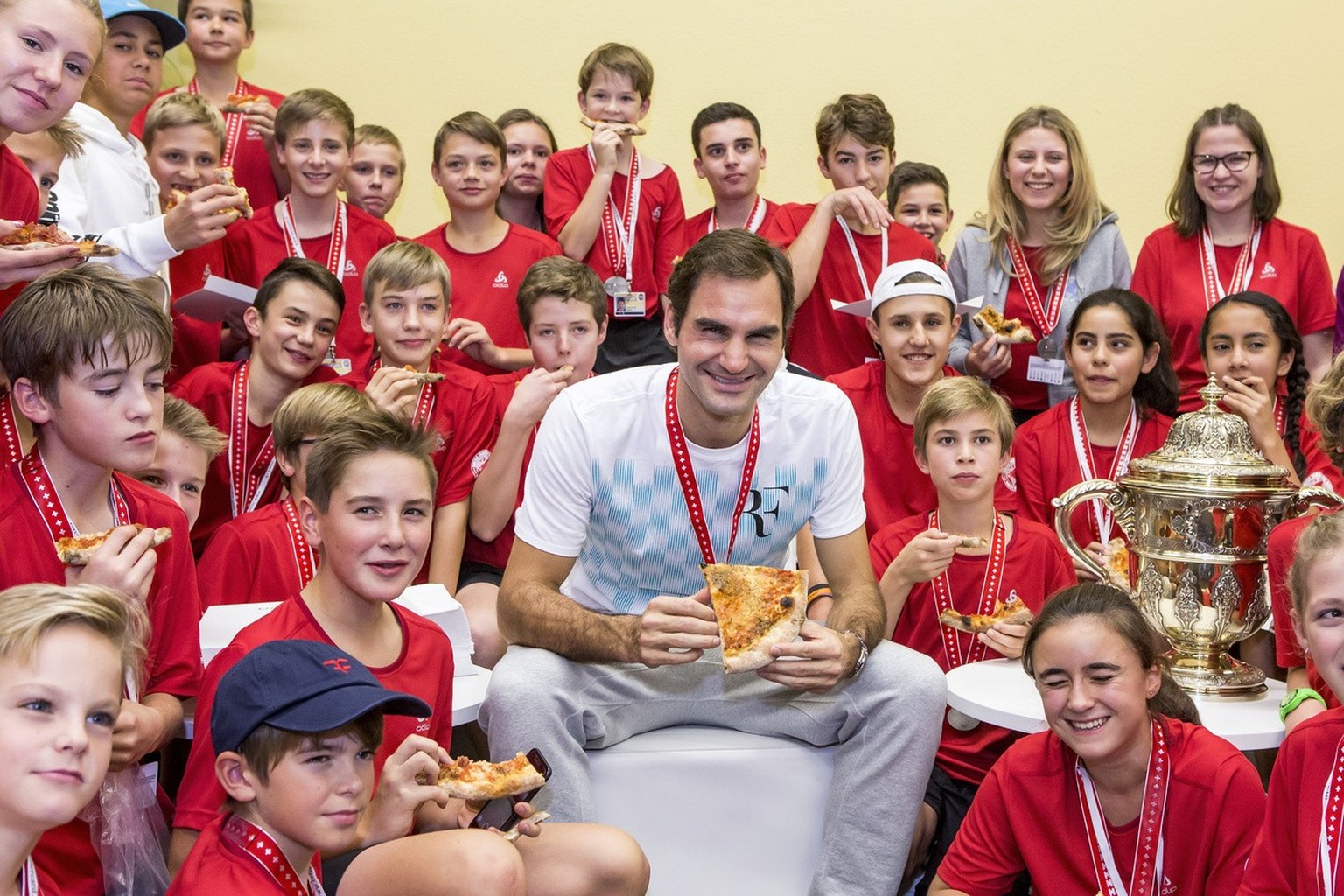 ARCHIV - RUECKTRITT ROGER FEDERER - Switzerland&#039;s Roger Federer eats pizza with ball kids after winning the final match against Argentina&#039;s Juan Martin Del Potro at the Swiss Indoors tennis  ...