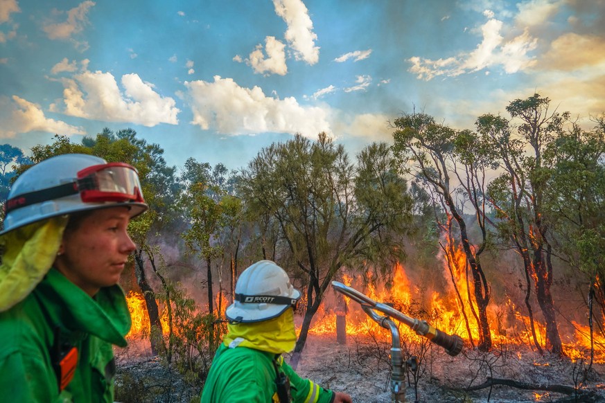 epa09635334 A handout photo made available by the Department of Fire and Emergency Services shows firefighters battling the Calgardup Bushfire burning in Margaret River, Weatern Australia, Australia,  ...