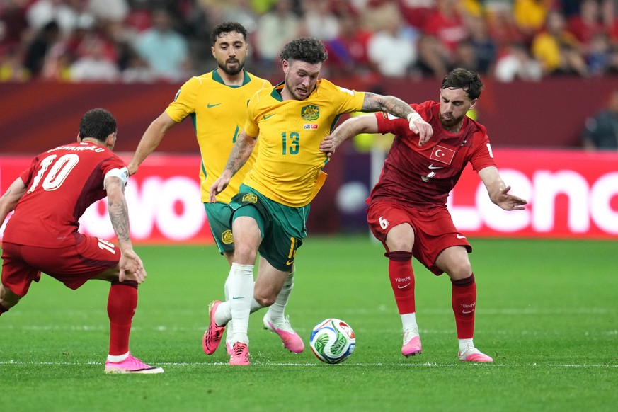 Australia's Aiden O'Neill (13) challenges for the ball with Turkey's Orkun Kokcu (6) during the World Cup Group D soccer match between Australia and Turkey in Vancouver, British Columbi ...