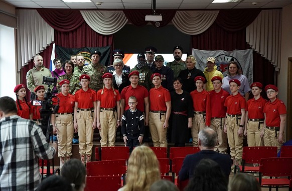 Schoolboy Ivan Ilyin, 7, poses with participants, including veterans and Russian Patriotic Youth movement Yunarmiya (Youth Army) cadets, during a ceremony led by local patriotic movements to reward Iv ...