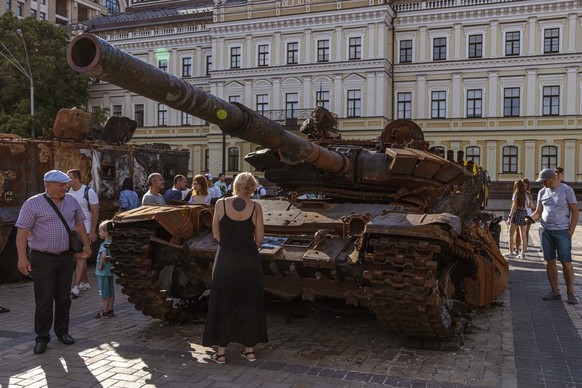 Les gens regardent un char russe qui a été détruit lors de combats avec l&#039;armée ukrainienne, exposé sur la place Mykhailivskyi, à Kyiv, Ukraine, le 12 juin 2022. Le 24 février, les troupes russes ...